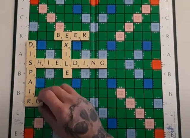 Scrabble board with hand putting letters on